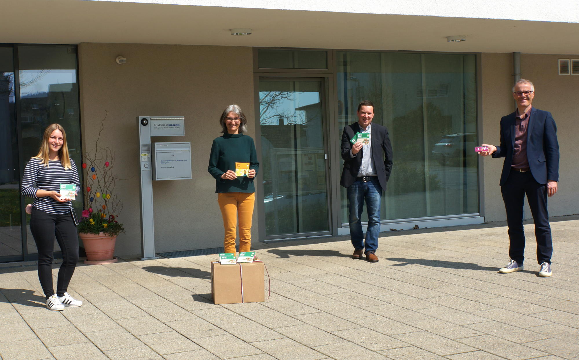 WeltPartner-Vorstand Thomas Hoyer (2vr.) überreicht an Kooperationspartner Andreas Weiß, Fachbereichsleiter der Sozialpsychiatrischen Hilfen der BruderhausDiakonie (re.), sowie an Karin Bruker, Sozialdienst (2 vl.) und Jessica Link, Pflegedienstleitung (li.) vom Seniorenzentrum Gustav-Werner-Stift in Weingarten die ersten Oster-Schokoladen für deren Pflegekräfte.