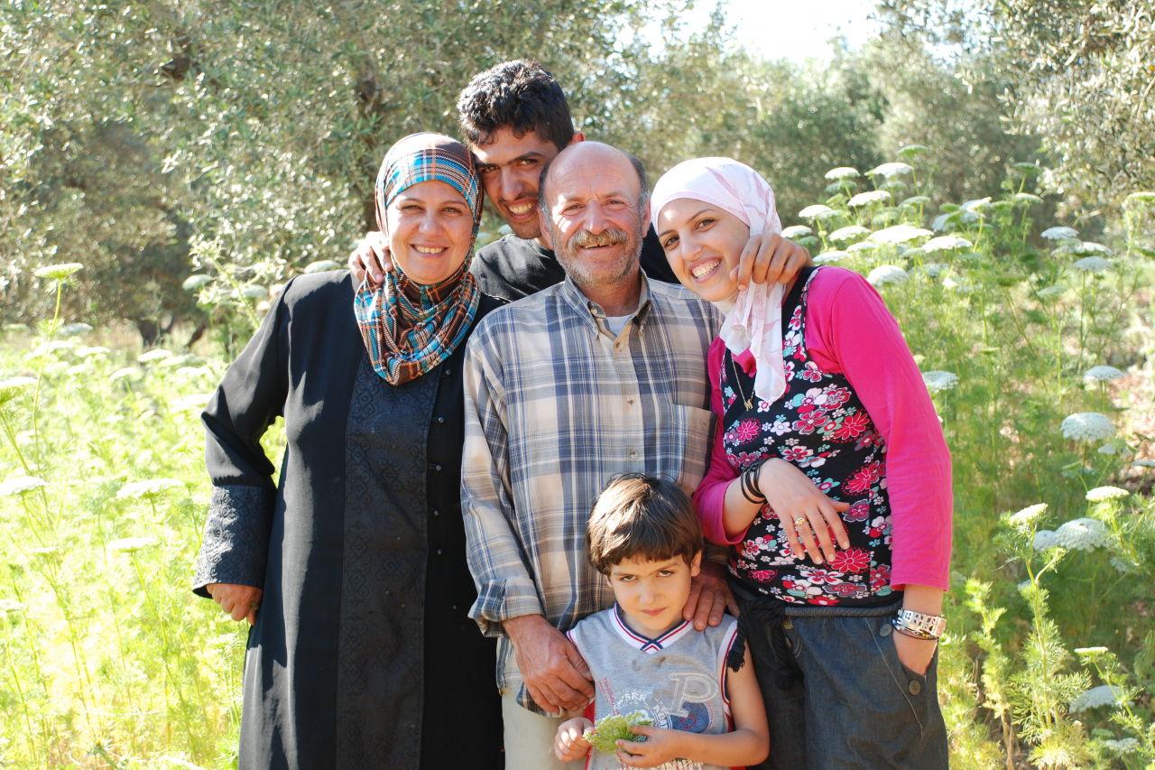 Palästinensische Kleinbauer-Familie lächelt vor ihren Olivenbäumen